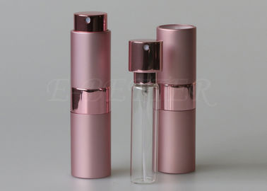 ピンクのねじれおよび噴霧器の頭部が付いている空の香水スプレーのびんを吹きかけるため